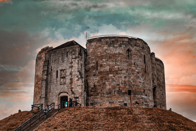 Low angle view of historic building against cloudy sky