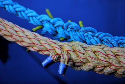 Close-up of rope tied up on blue metal