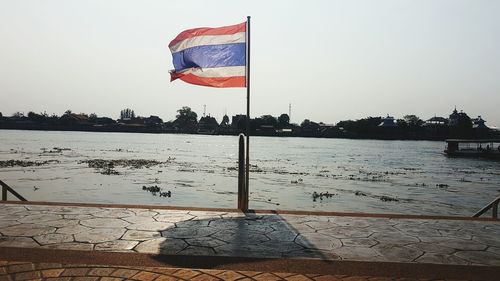 Flag on pole against clear sky