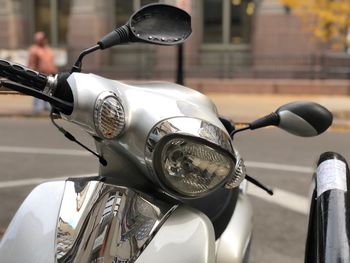 Close-up of motor scooter on road