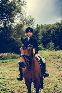 Portrait of happy boy sitting on horse