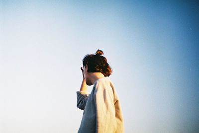 Woman standing against clear sky