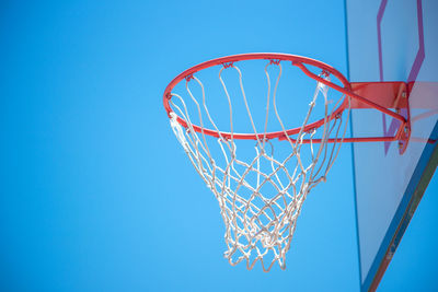 Low angle view of basketball hoop against blue sky