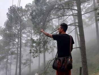 Full length of woman standing in forest during winter