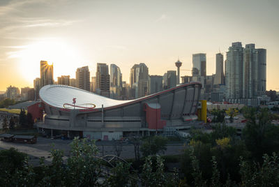 Modern buildings in city against sky during sunset
