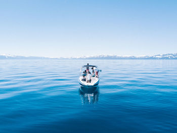 Boat in sea against clear blue sky