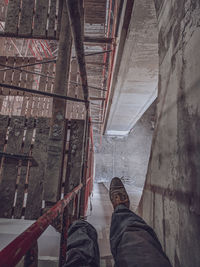 Low section of man standing on ceiling in building