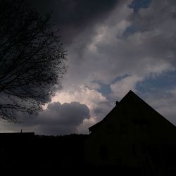 Low angle view of silhouette building against sky