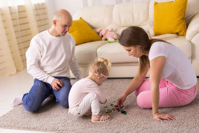 High angle view of family sitting on bed at home