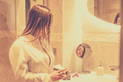 Rear view of woman sitting at home