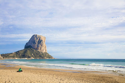 High angle view of man sitting on sandy beach