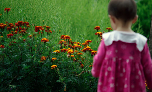 Rear view of girl standing on field