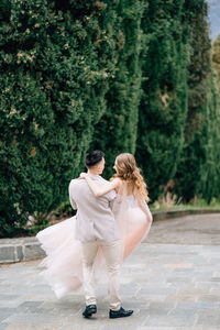 Rear view of couple standing against trees