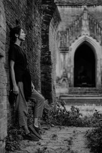 Rear view of man walking by historic building