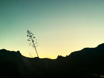 Silhouette mountains against clear sky during sunset