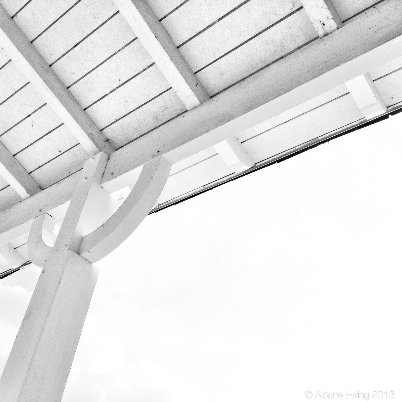 low angle view, built structure, architecture, architectural column, clear sky, column, no people, day, indoors, directly below, ceiling, part of, sky, building exterior, support, sunlight, metal, architectural feature, copy space