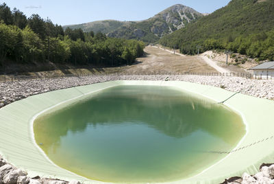 Swimming pool by mountains against sky