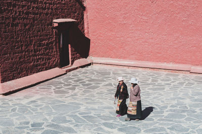 High angle view of men on footpath against building