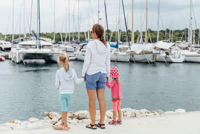 Rear view of woman on sailboats moored at harbor