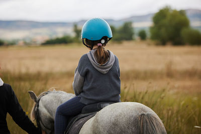 5-year-old girl riding on a horse, in a hipico club. infalltil sport concept.