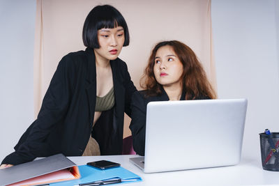 Lesbian couple working in office