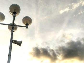 Low angle view of street light against cloudy sky