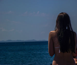 Rear view of woman looking at sea against sky