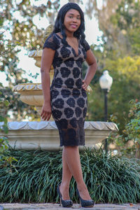 Portrait of a smiling young woman standing against plants