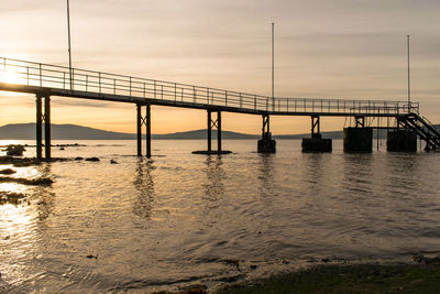 View of bridge over sea against cloudy sky