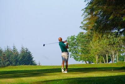 Full length of man on golf course against sky