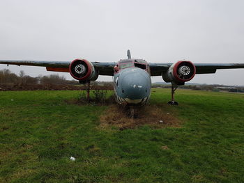 Vintage airplane on grass against sky