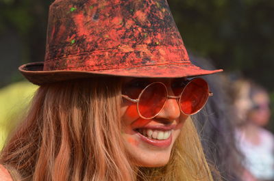 Close-up of smiling woman wearing sunglasses and hat