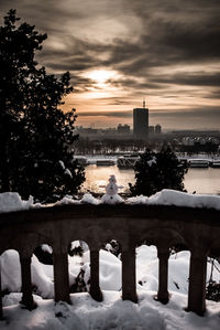 Bridge over river during sunset in city