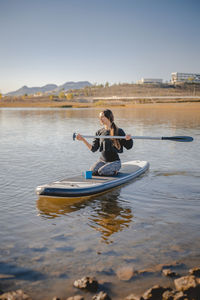 Man in boat on lake against sky