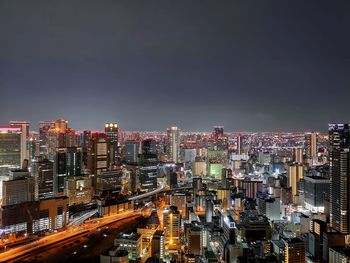 Illuminated cityscape against sky at night