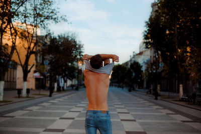 Rear view of man standing on footpath