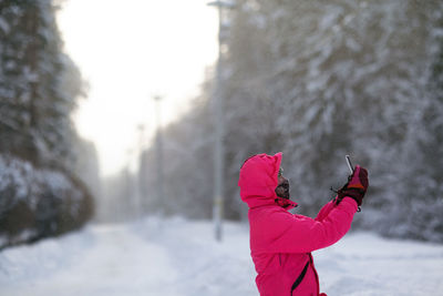 Midsection of person standing by snow during winter