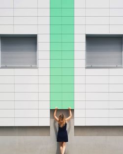 Full length of young man standing against wall