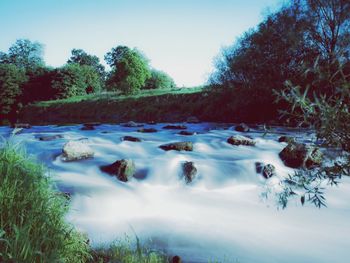 Scenic view of waterfall against sky