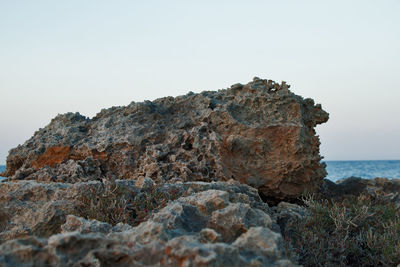 Rock formations in sea against clear sky
