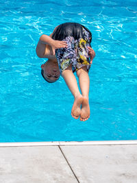 Rear view of young woman swimming in pool