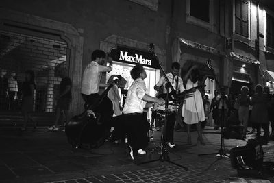 People playing guitar on street in city