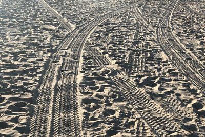 High angle view of tire tracks on sand