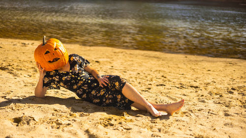 High angle view of woman sitting on sand at beach