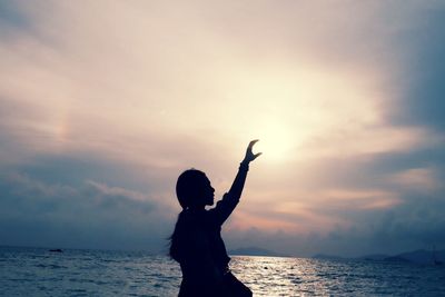 Silhouette man on beach against sky during sunset