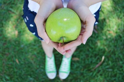 Midsection of woman holding fruit
