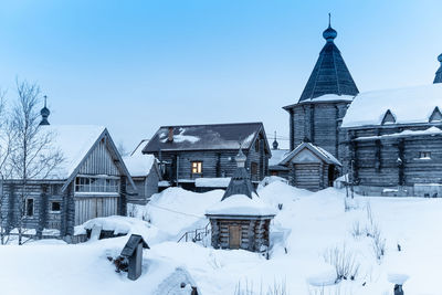 Snow covered buildings against sky