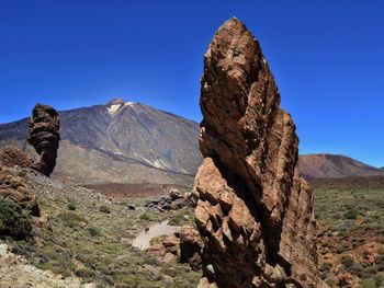 Scenic view of mountains against clear blue sky