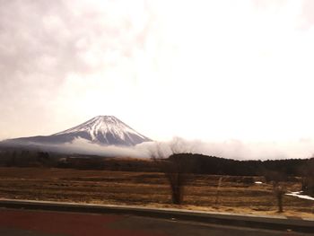 Road by mountains against sky