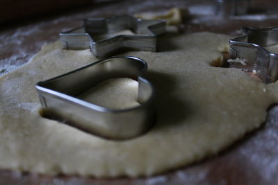 Close-up of pastry cutters on dough at table